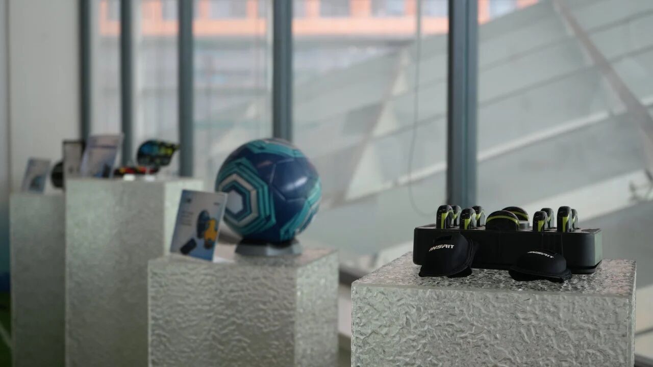 Inside Gengee office showroom featuring a diverse range of soccer wearable technology and smart connected balls on display stands.